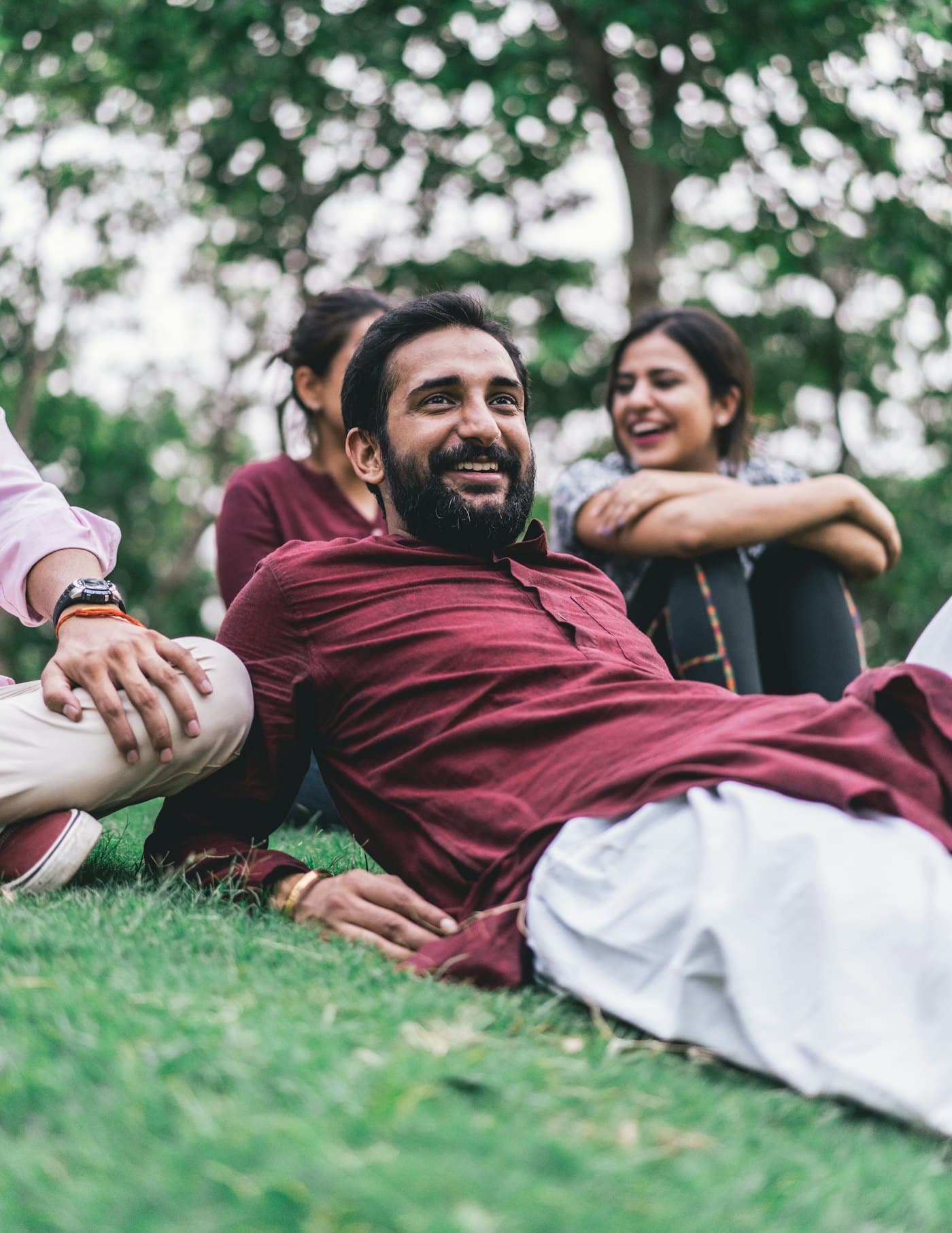 A family laughing together on the grass in a park