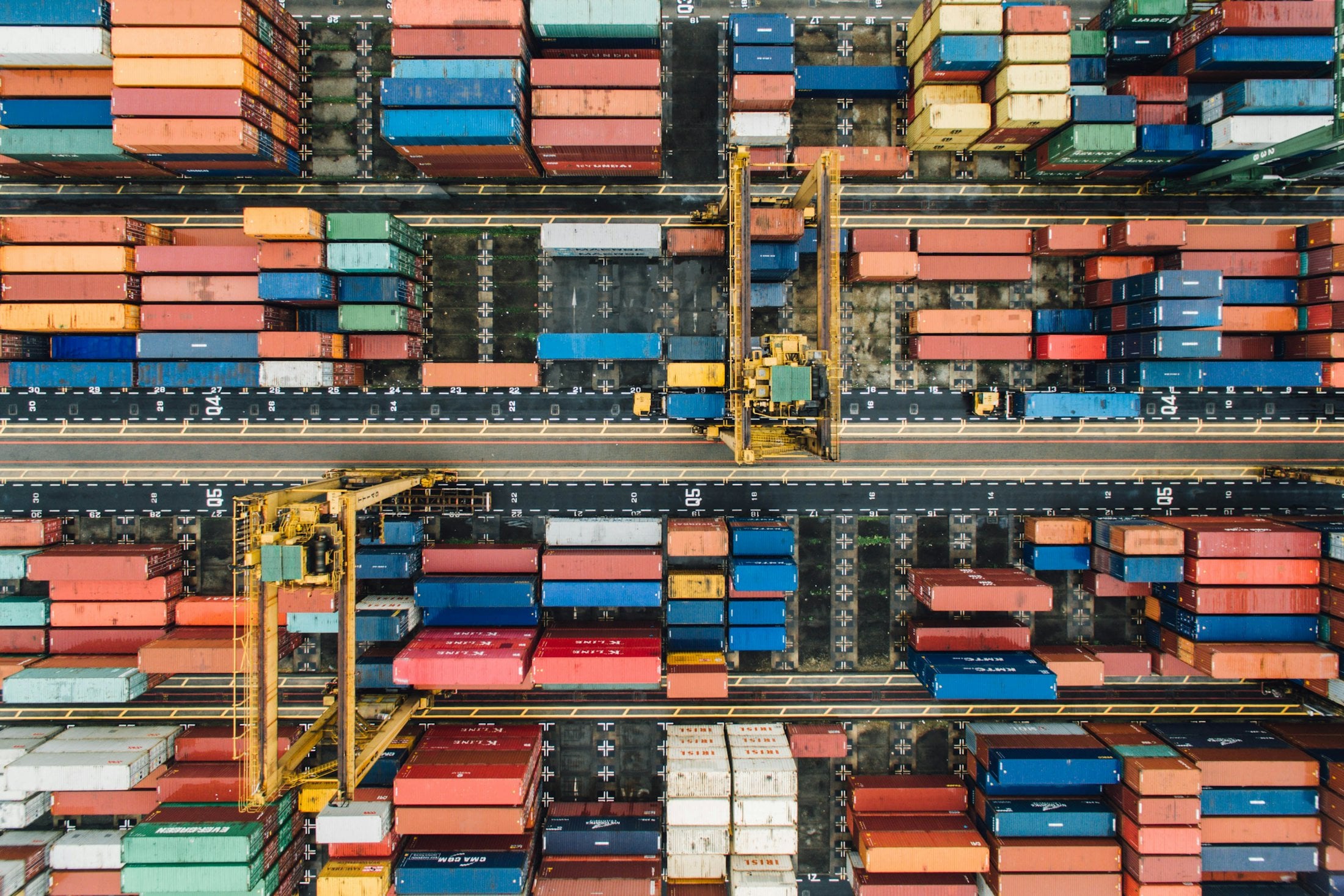 An aerial view of shipping containers and cranes at a busy port